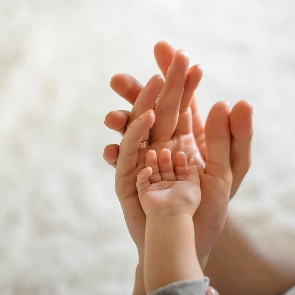 Woman, man and baby hand